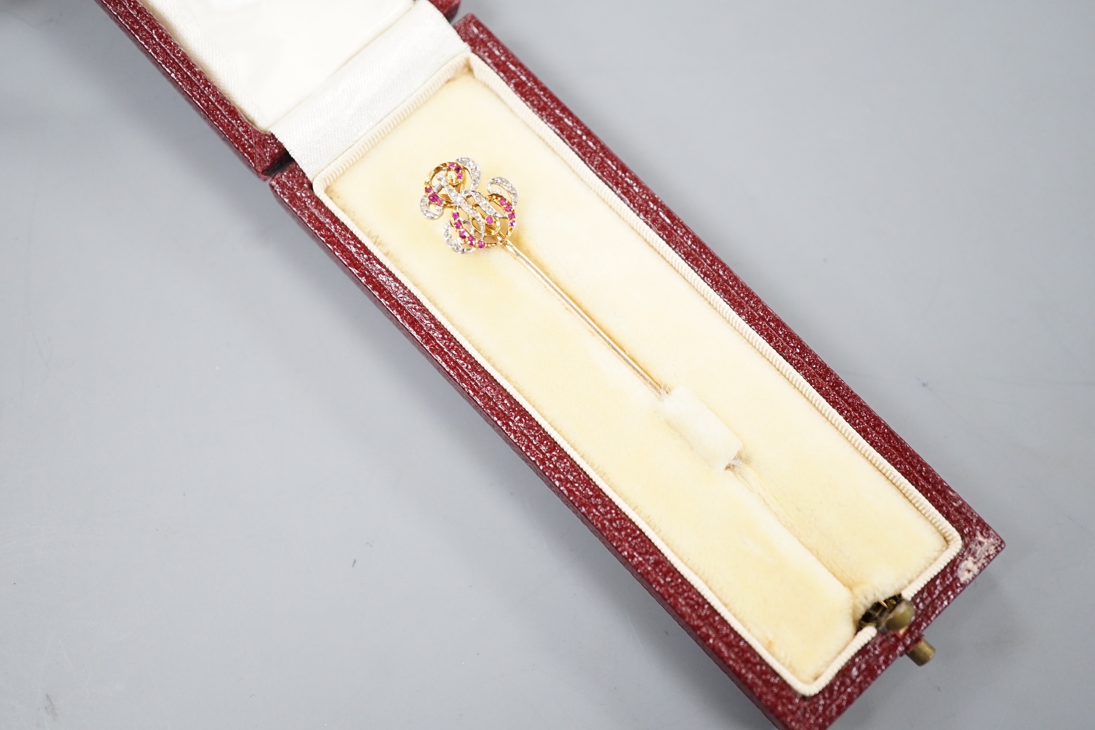 An early 20tyh century French yellow metal (18ct poincon mark) ruby and diamond set 'ER' monogram stick pin, 70mm, gross weight 2 grams, in Sewell of Berkeley Square red leather box.
